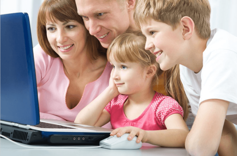 Dwójka dorosłych wraz z dwójką dzieci patrzą się w ekran laptopa