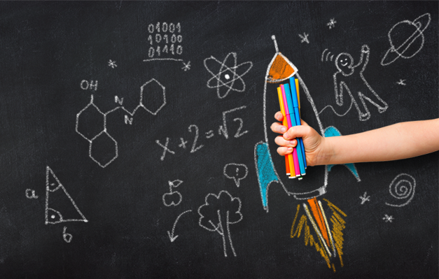 Dziecko trzymające flamastry w środku narysowanej na tablicy rakiety